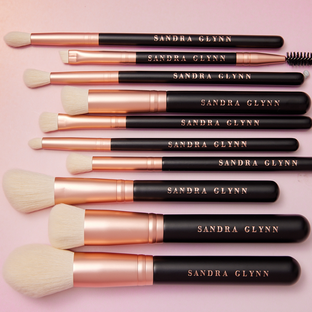 Set of Sandra Glynn makeup brushes on a pink background