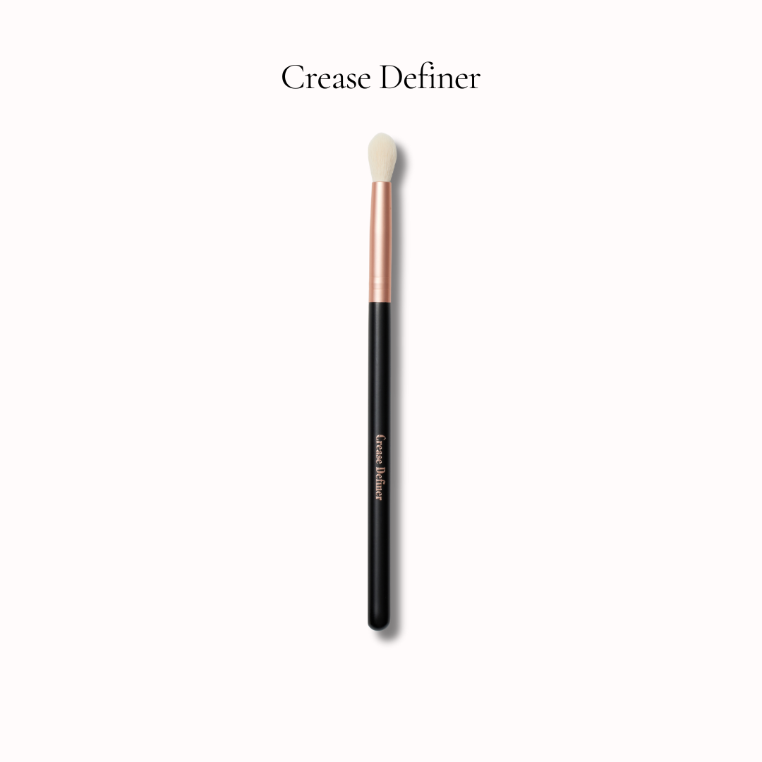 Makeup brush labeled 'Crease Definer' on a white background